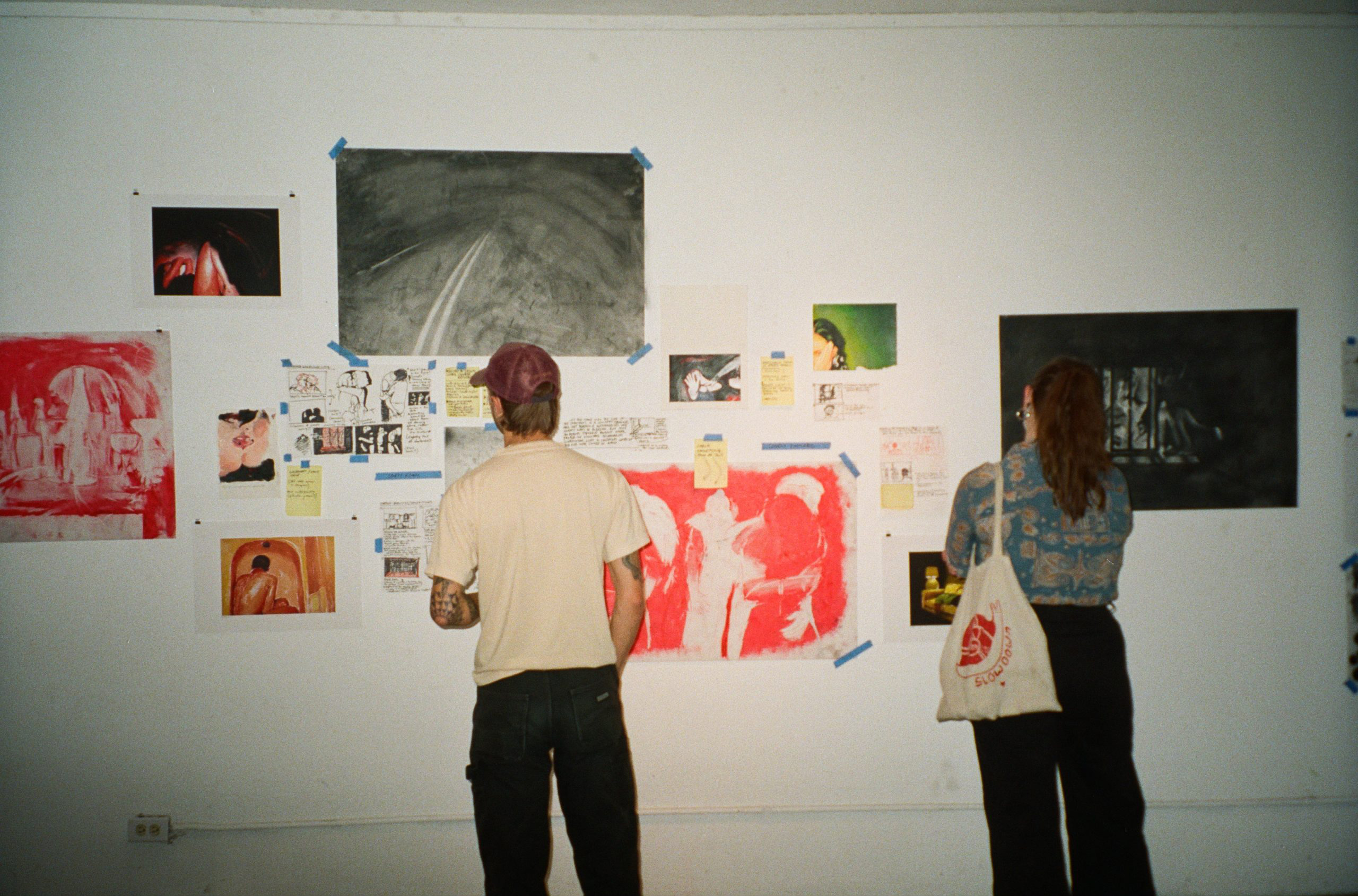 Visitors looking at visual artist Alissa Zilber’s drawings and paintings during her open studio exhibition at the Ministry of Casual Living in Victoria, British Columbia.